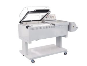 Retractiladora F7060 con la campana abierta y el rollo de film al lado
